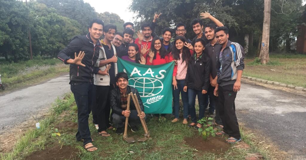 Group of people holding a green flag with "IAAS" and a globe symbol